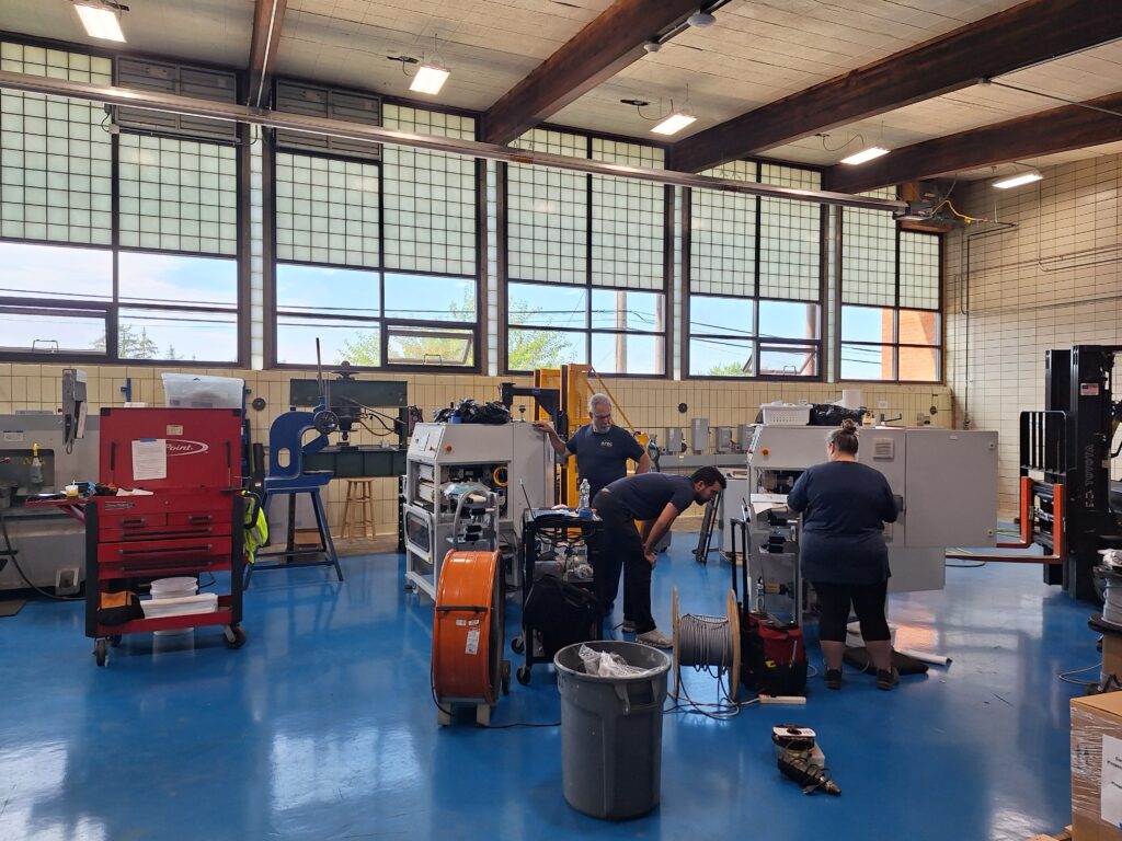 Employees create specialty machinery in the former pool space.